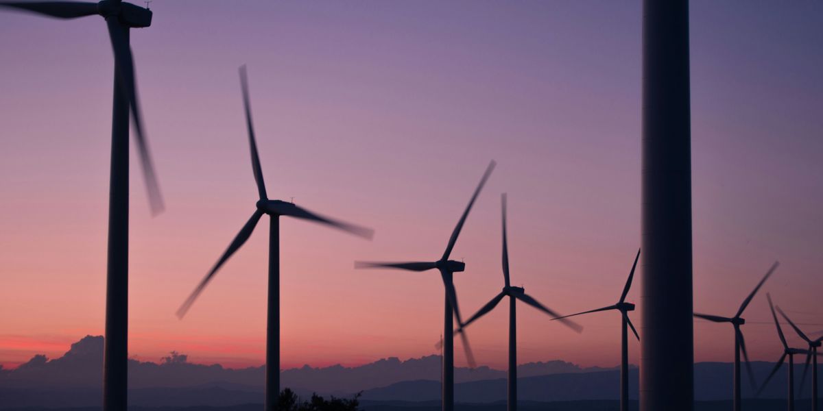 silhouette of wind turbines during sunset.
