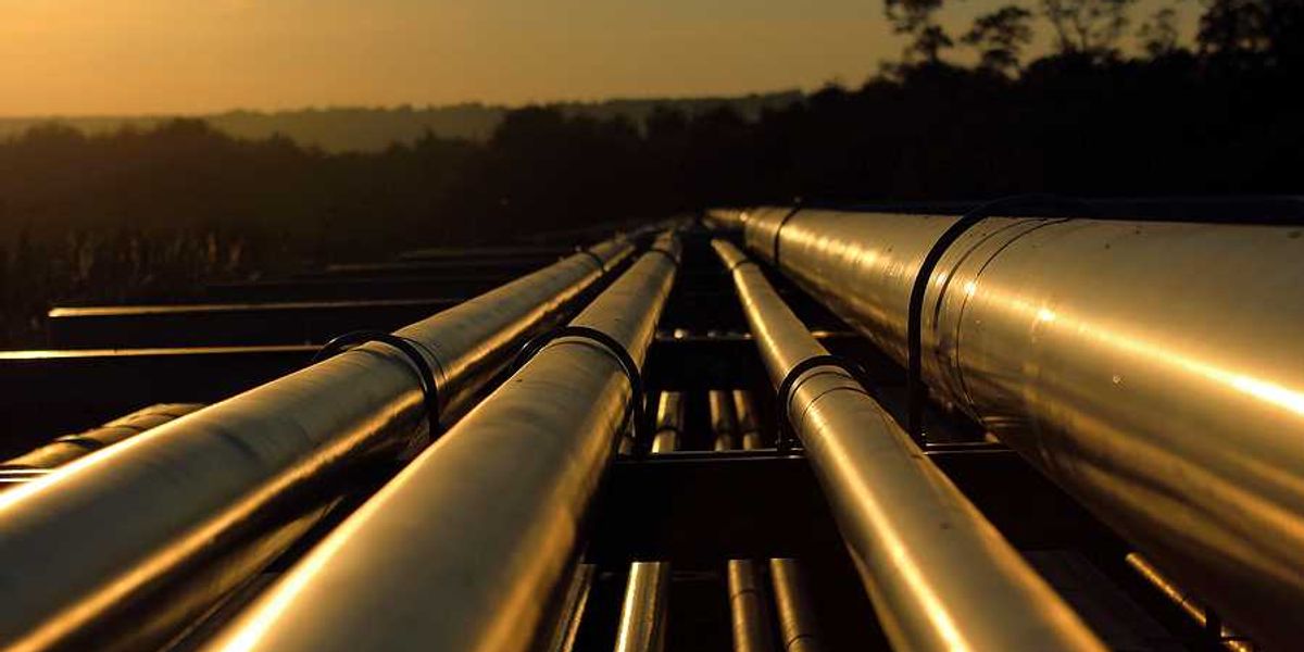 Silver pipelines stretching into the distance at sunset