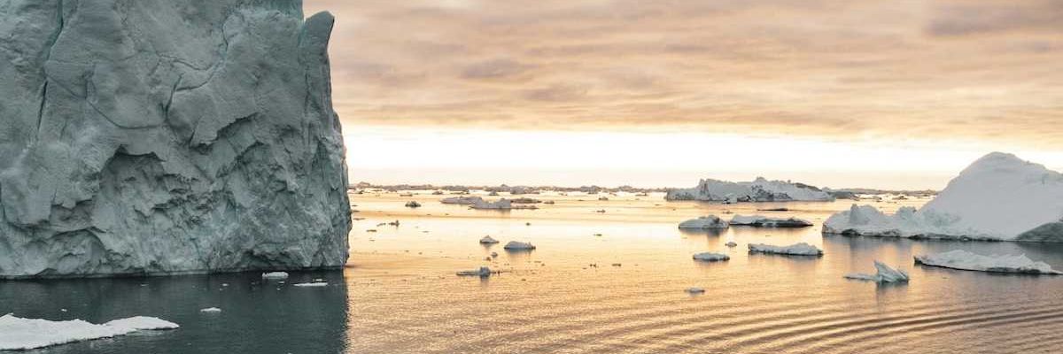 Small motorized boat navigating ice-choked waters off the coast of Greenland