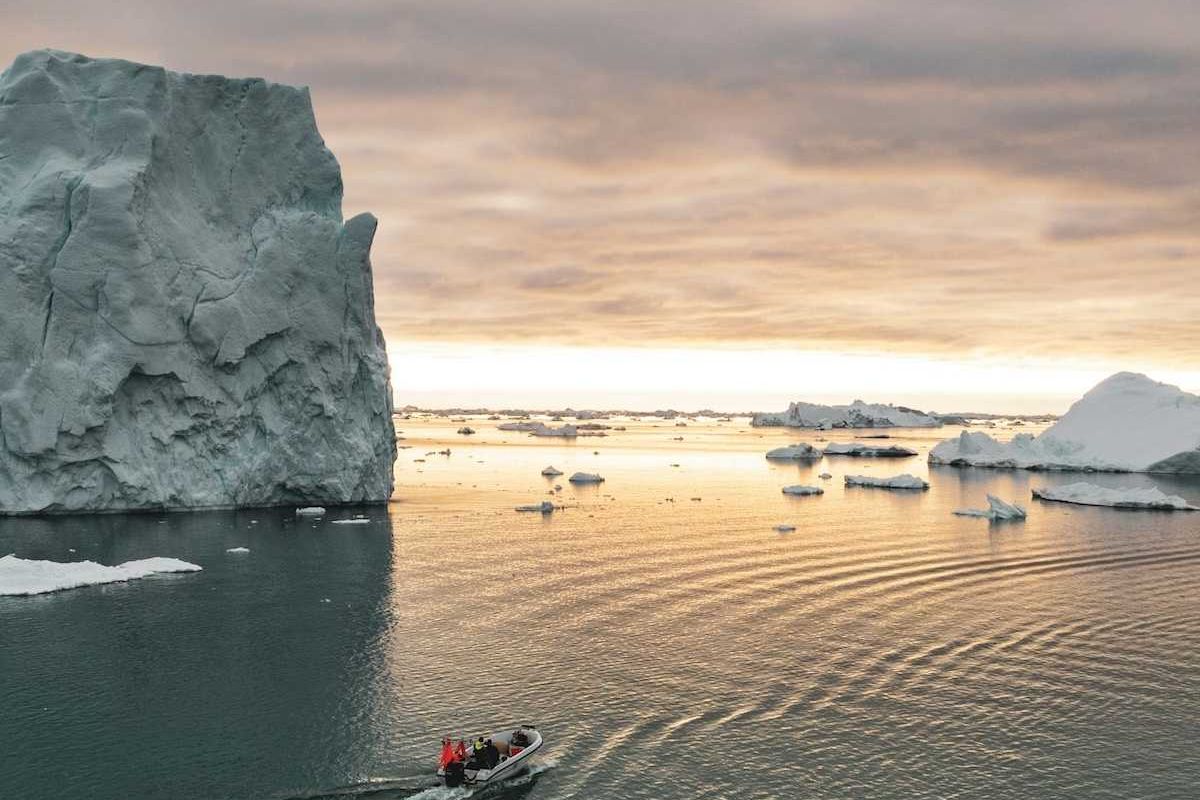 Small motorized boat navigating ice-choked waters off the coast of Greenland