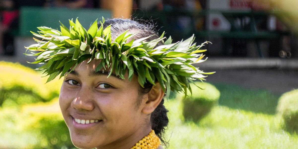 smiling woman wearing a crown of green leaves