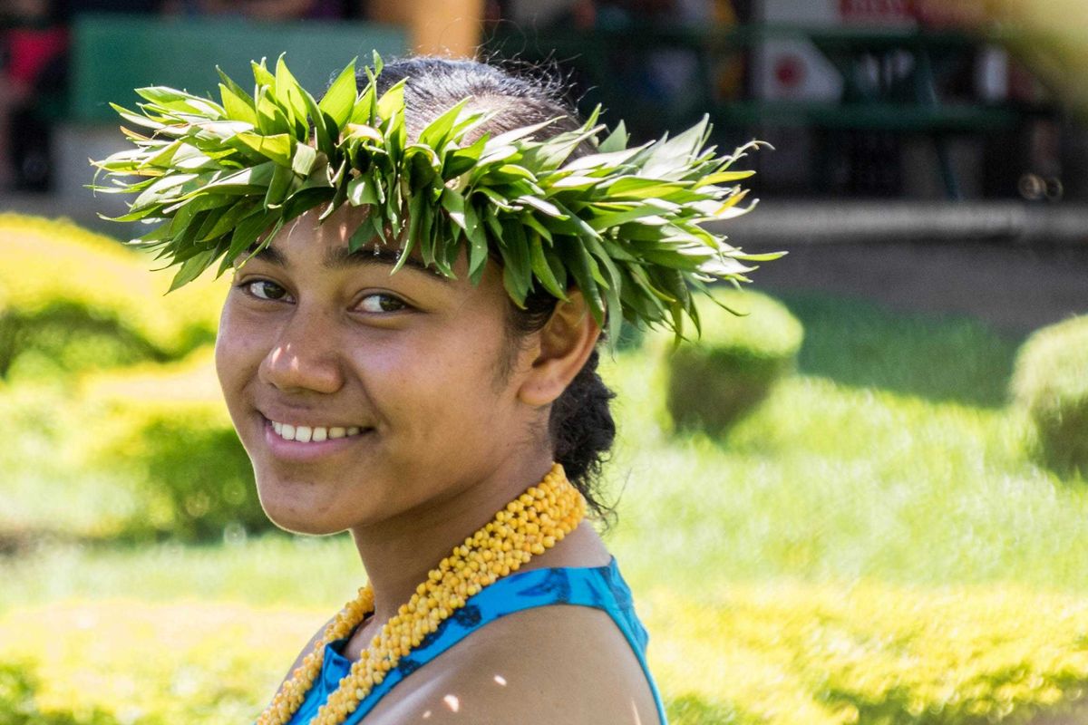 smiling woman wearing a crown of green leaves