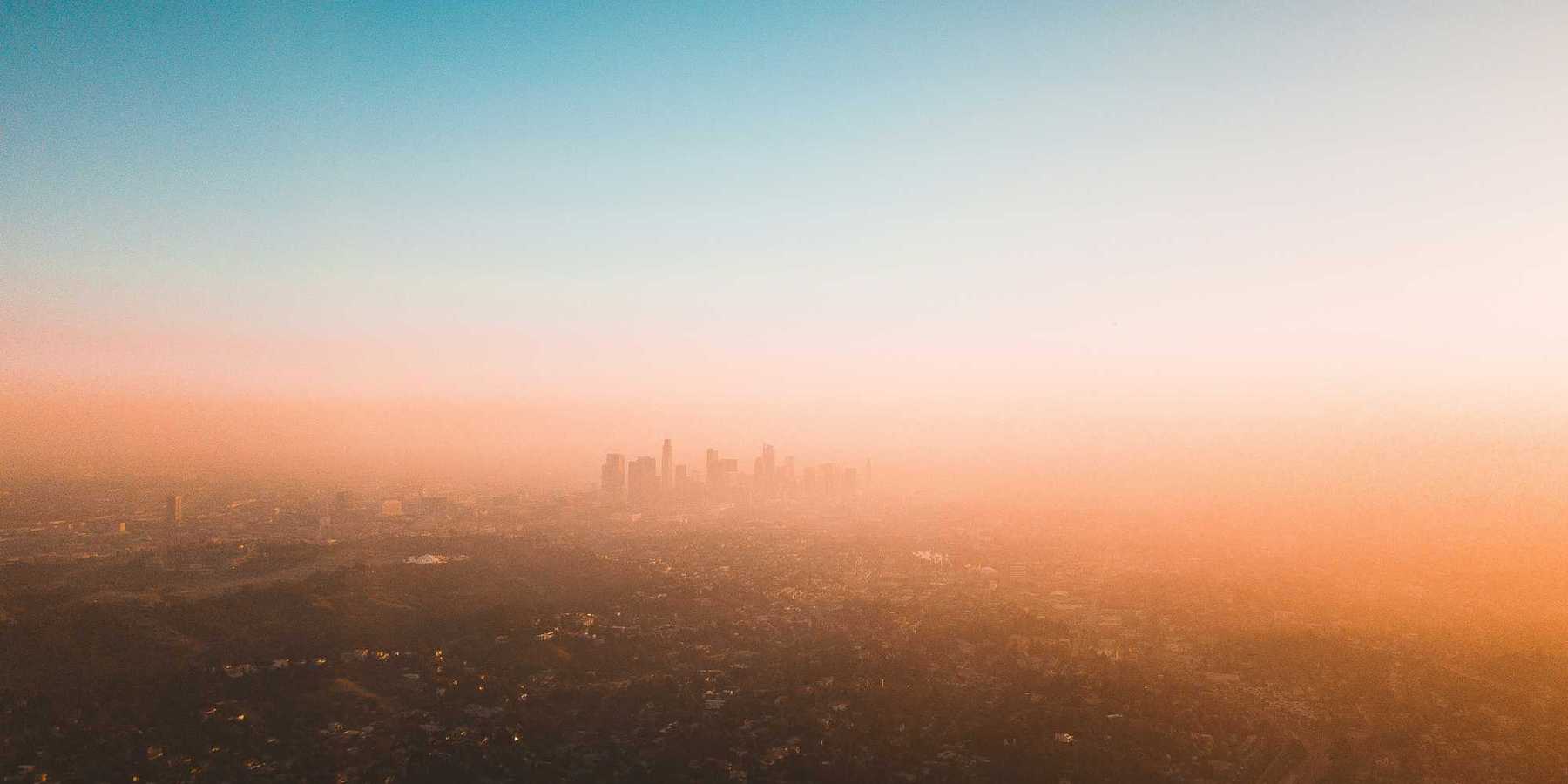 Smoggy Los Angeles skyline with skyscrapers in distance.