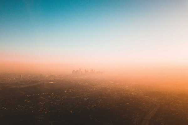 Smoggy Los Angeles skyline with skyscrapers in distance.