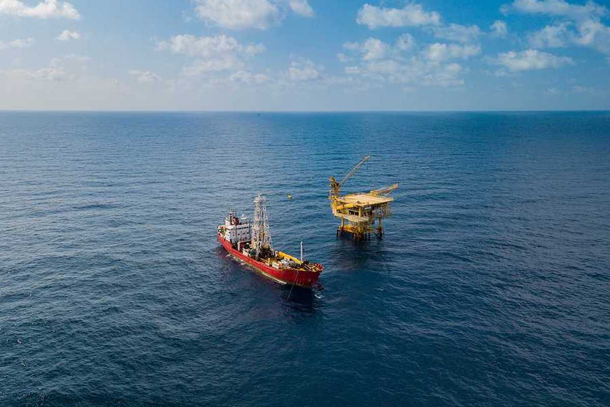 Soil Boring Boat aka survey vessel close to an oil platform in open ocean.