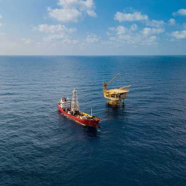 Soil Boring Boat aka survey vessel close to an oil platform in open ocean.