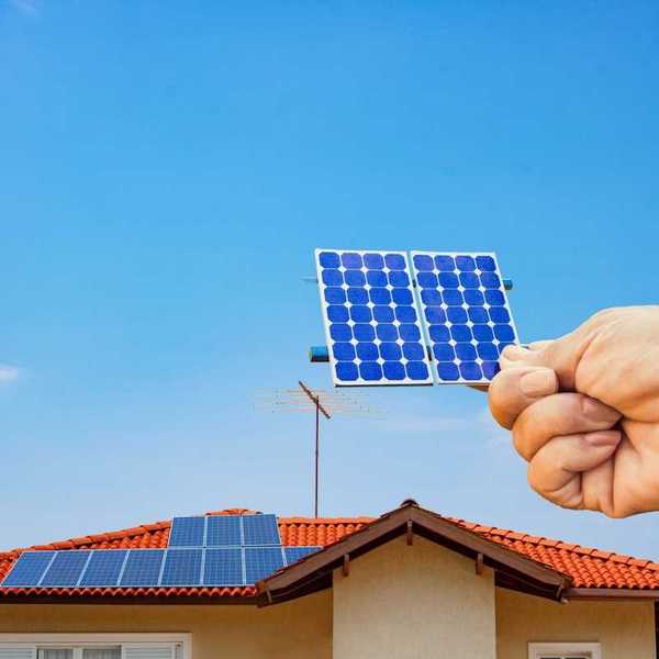 Solar energy panel shown with a hand holding a photovoltaic cell,