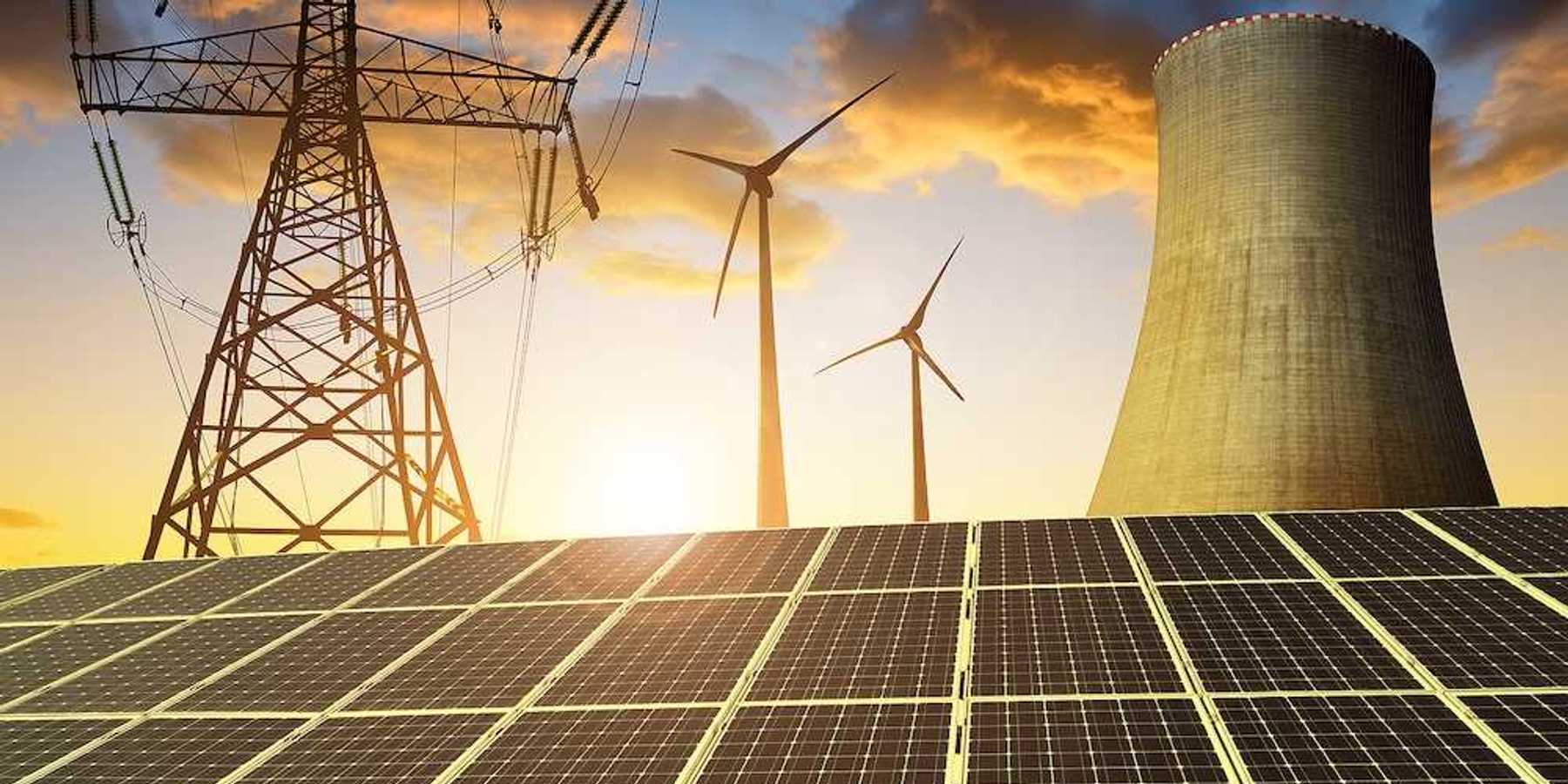 Solar panels in the background nuclear power plant, wind turbines and electricity pylon at sunset.
