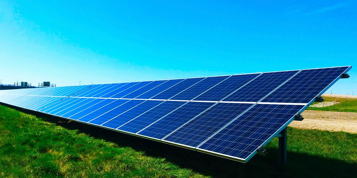 Solar panels set up in a green field.