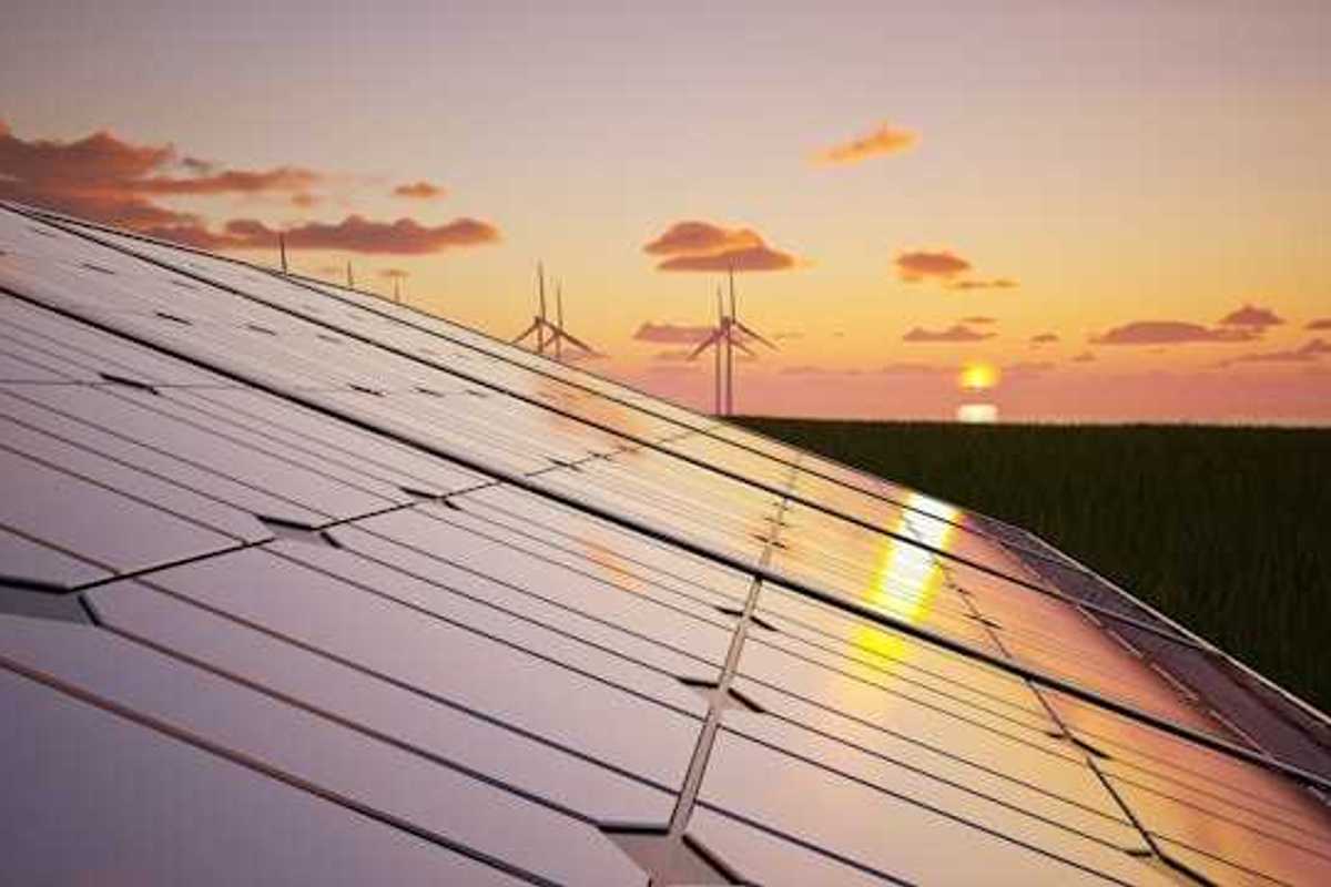 Solar panels with wind turbines and a setting sun in the background