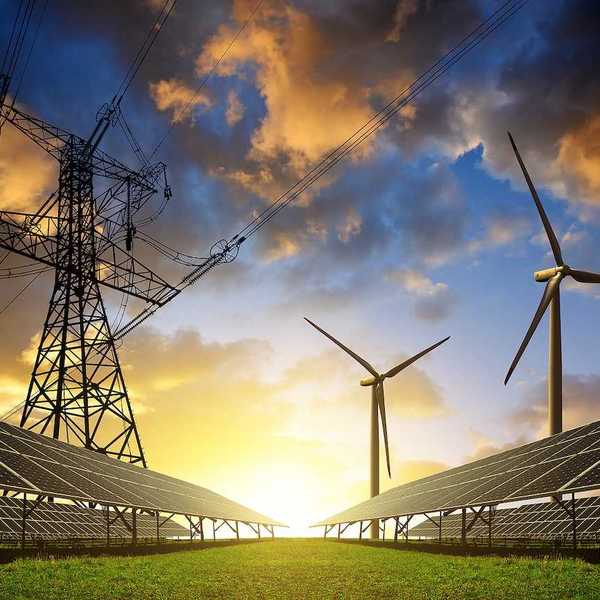 Solar panels with wind turbines and high voltage powerlines overhead