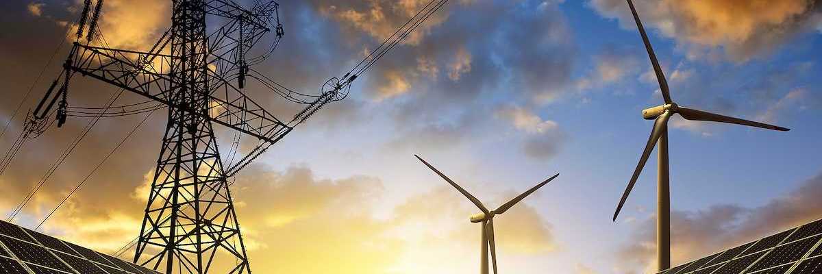 Solar panels with wind turbines beneath electrical transmission lines at sunset.