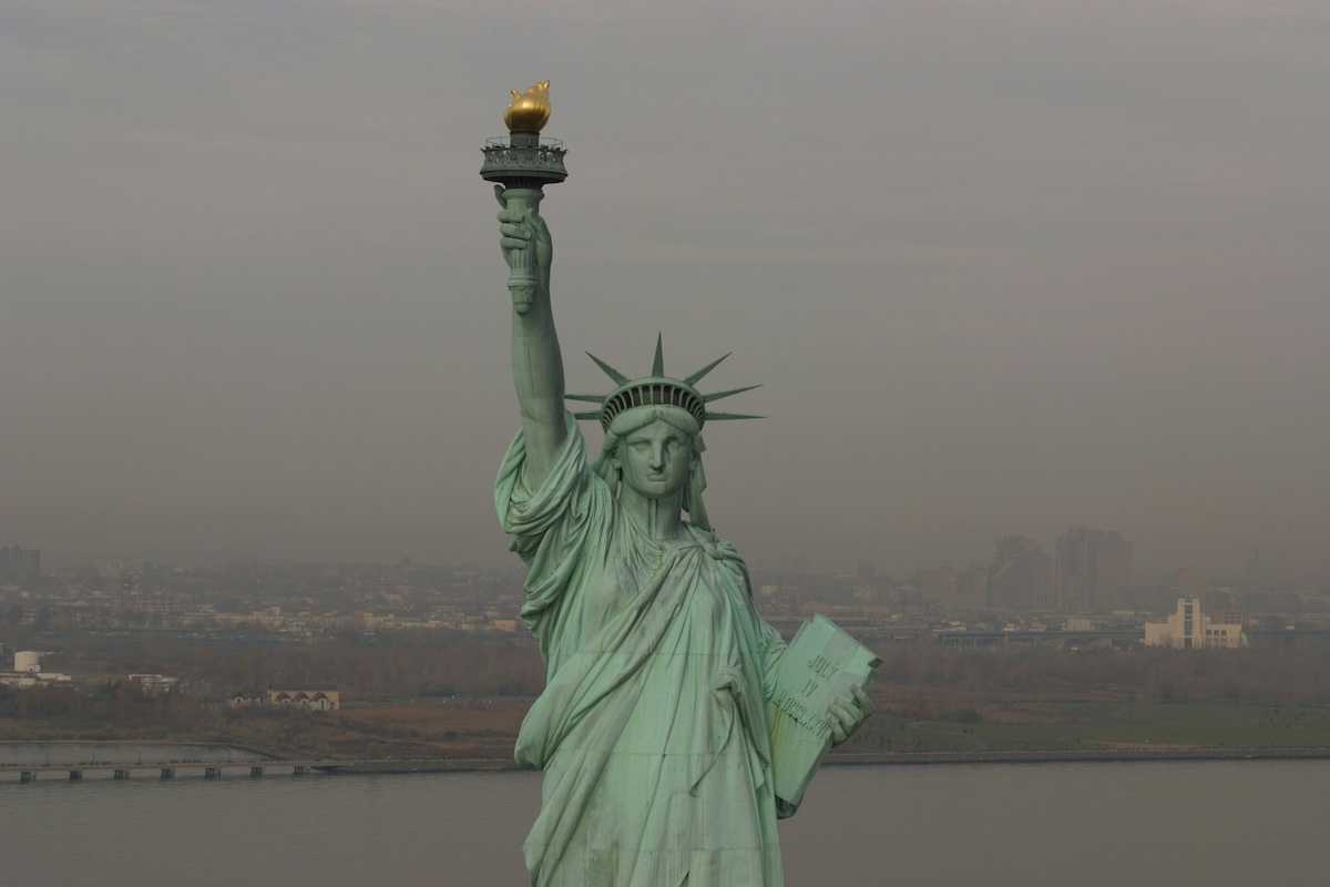 Statue of Liberty against a smoky, smoggy, sky and backdrop