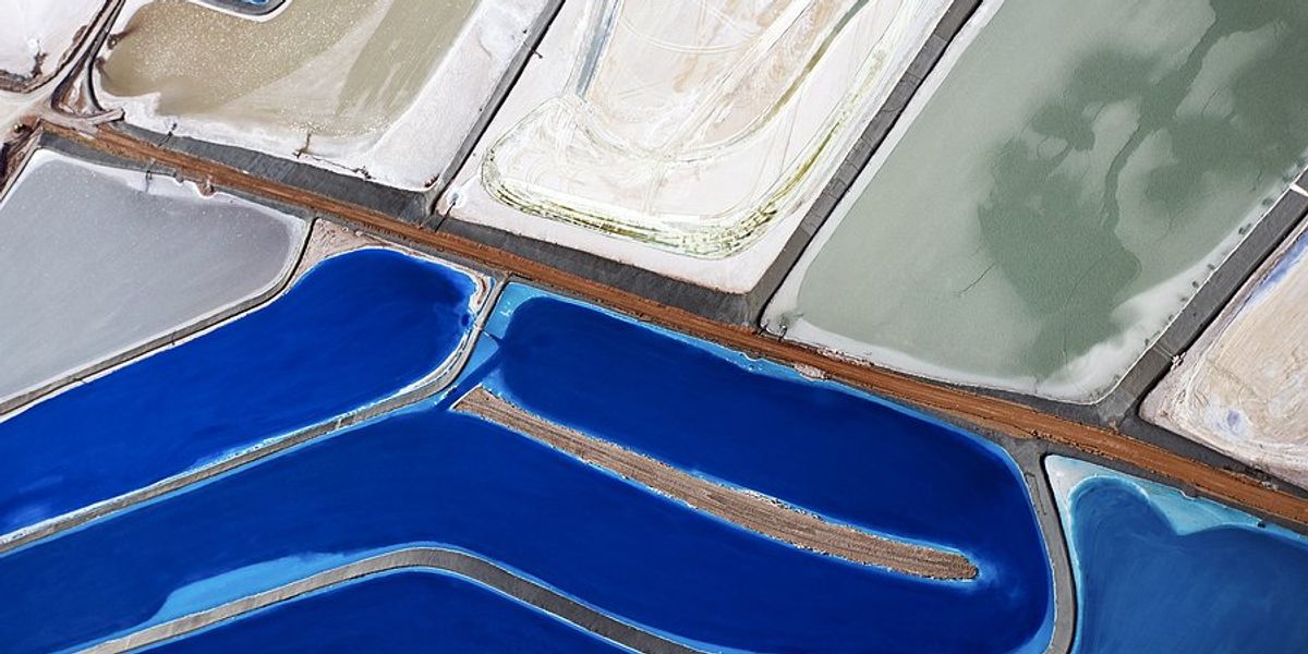 Tailings ponds with different colored water and waste viewed from above.