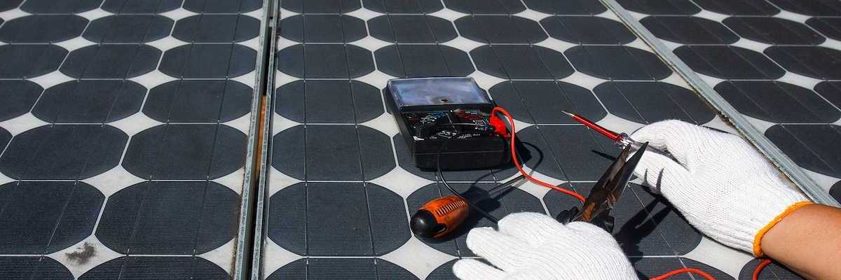 Technician using multimeter to repair photovoltaic modules