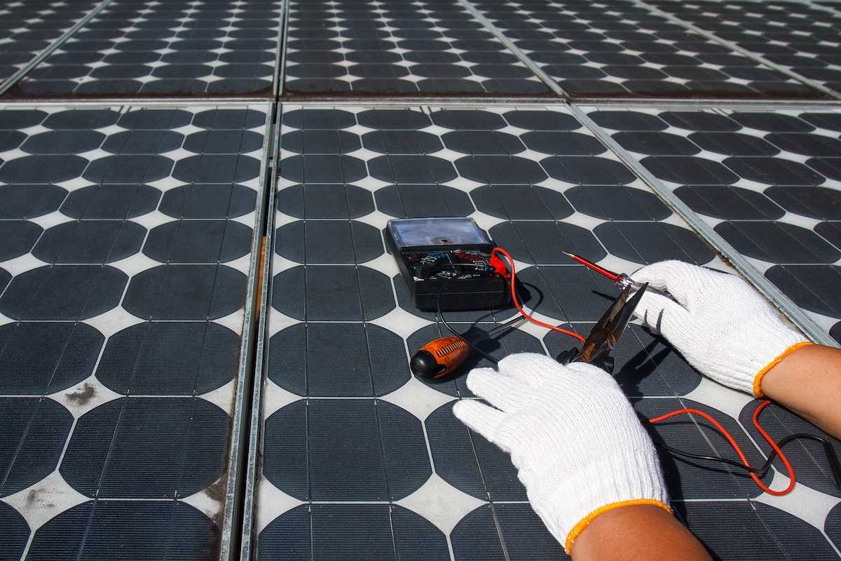 Technician using multimeter to repair photovoltaic modules