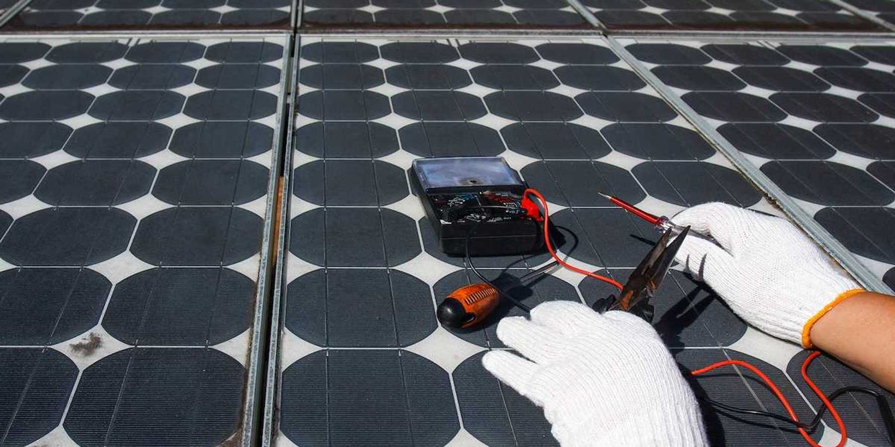 Technician using multimeter to repair photovoltaic modules