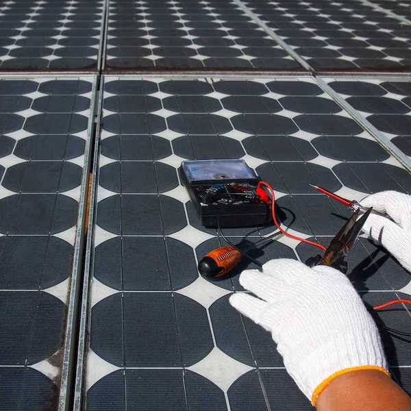Technician using multimeter to repair photovoltaic modules