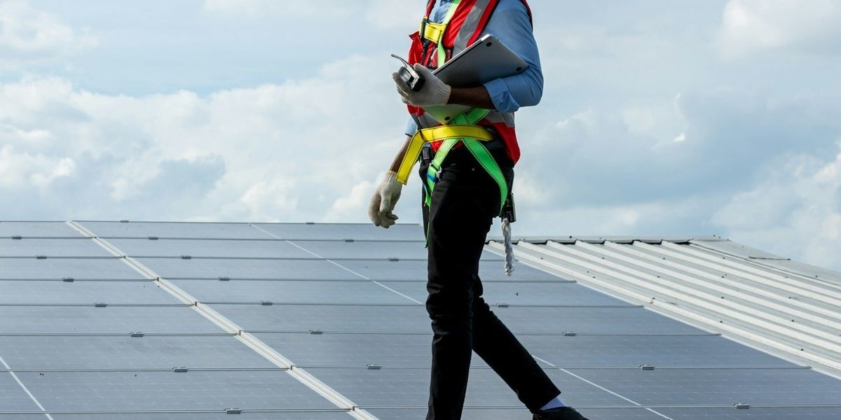 Technician walking across rooftop solar installation