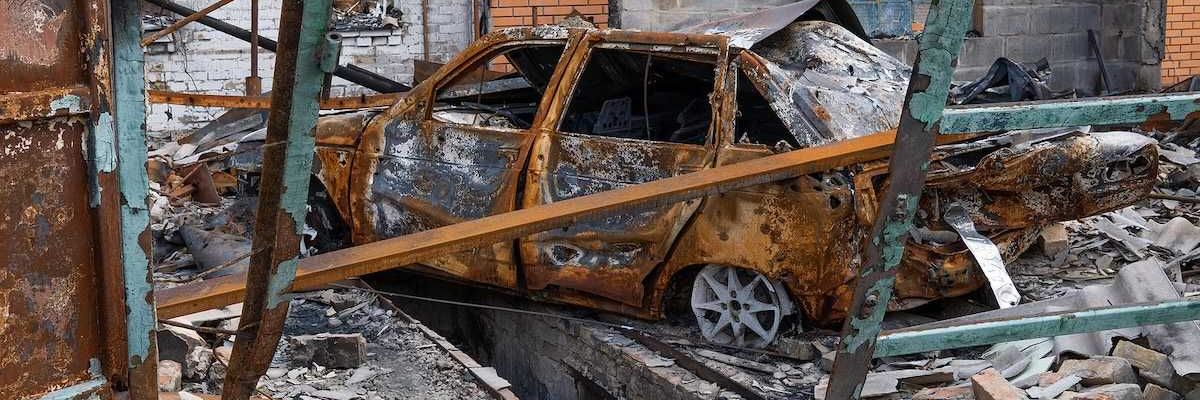 The car burned down in the garage of a house. Explosion and fire in the workshop. Soot and coal around.