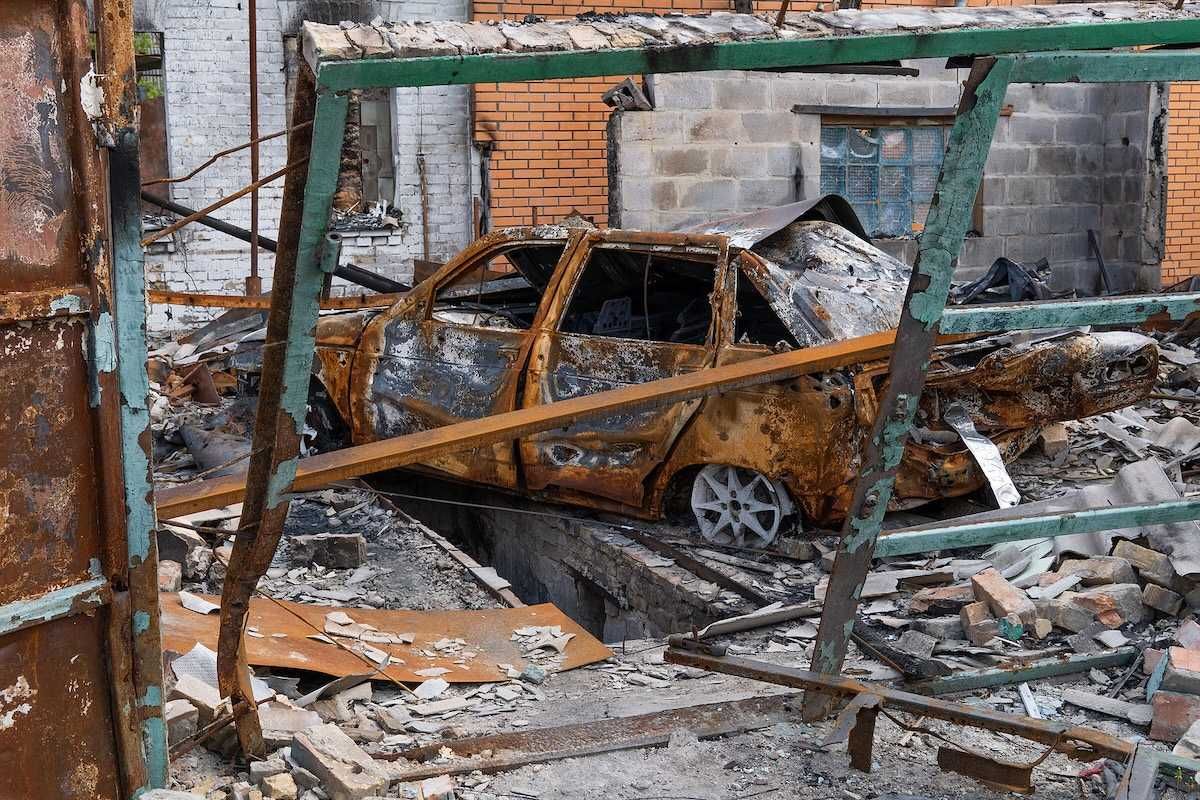 The car burned down in the garage of a house. Explosion and fire in the workshop. Soot and coal around.