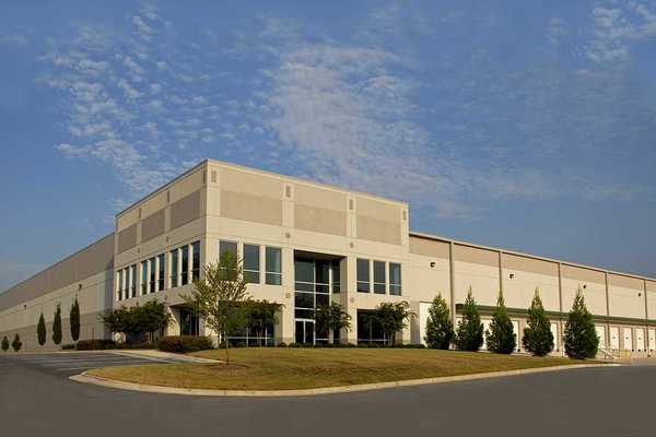The exterior of a generic warehouse building with the blue sky in the background