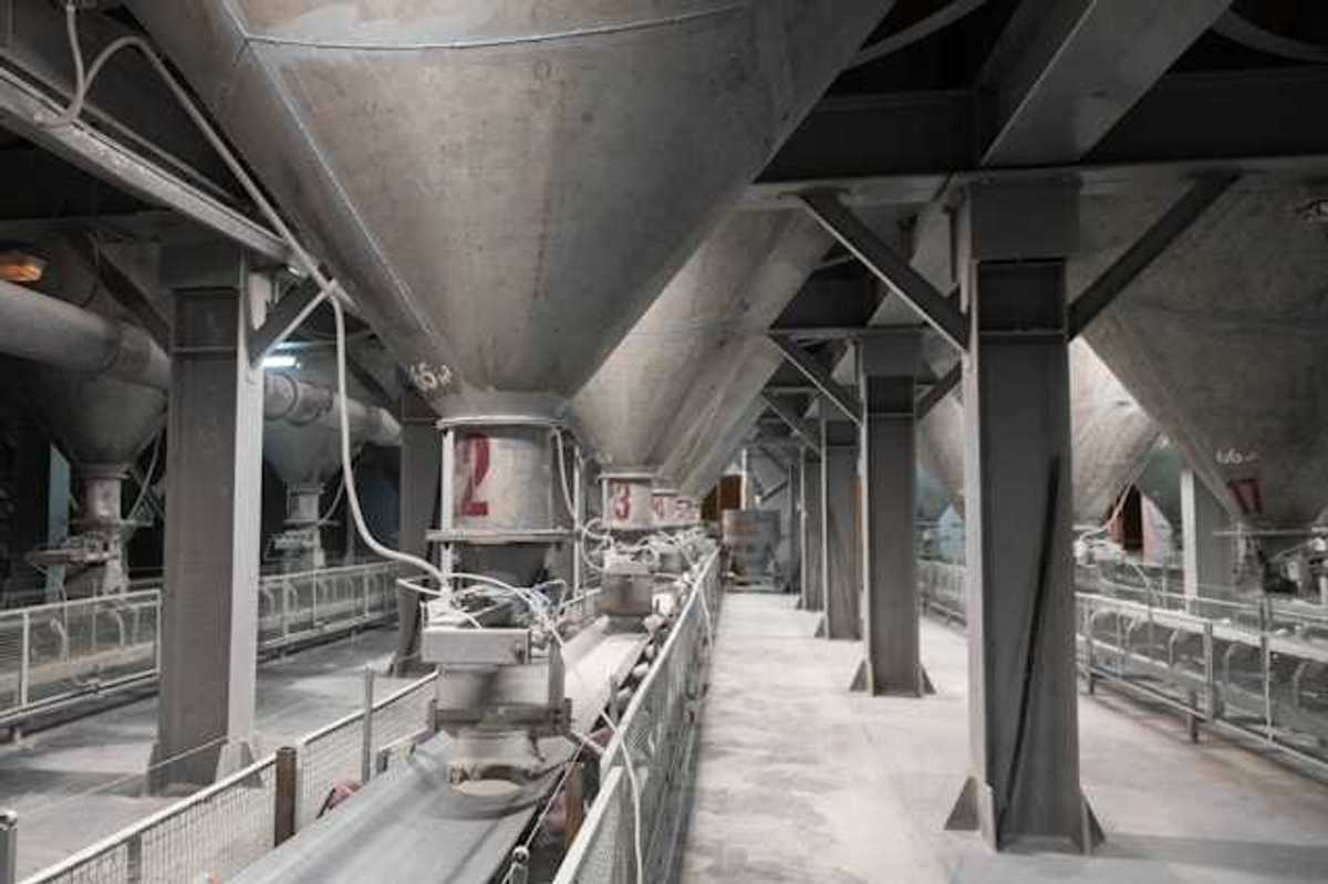 The interior of a cement plant with funnels leading to conveyer belts