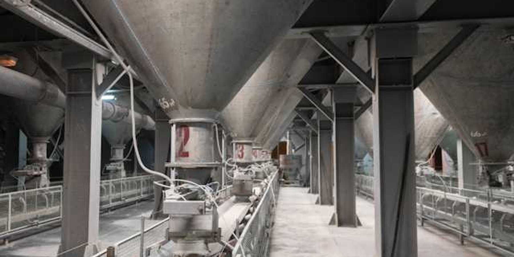The interior of a cement plant with funnels leading to conveyer belts