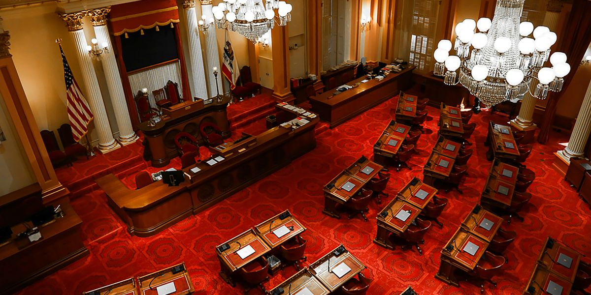 The interior of the Sacramento capitol building photographed from above looking down on desks and chairs.