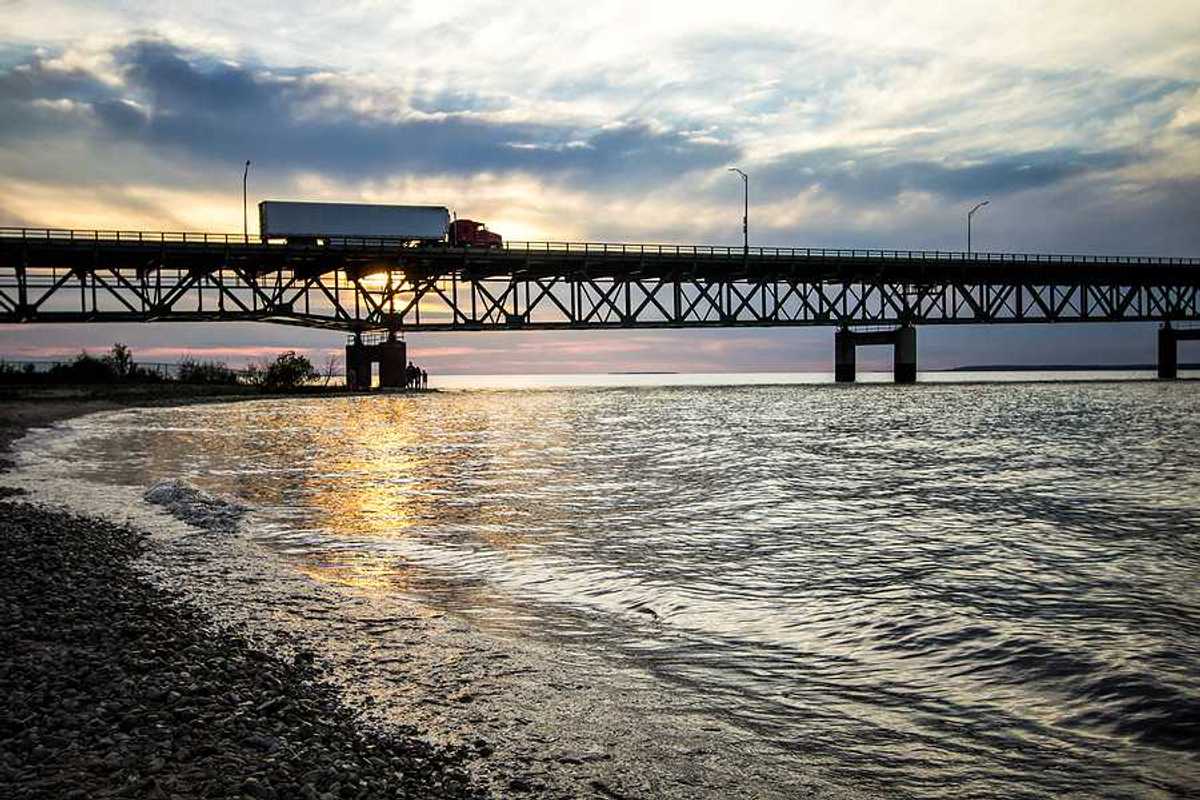 The Mackinaw Bridge stretching across a body of water at sunset