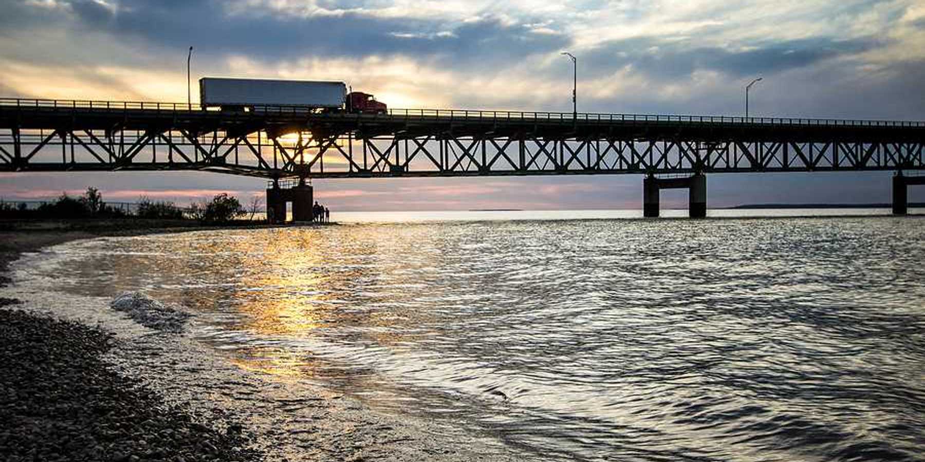 The Mackinaw Bridge stretching across a body of water at sunset