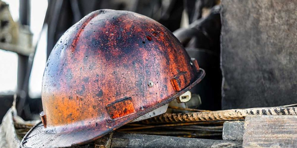 The protective helmet of an oil worker is stained with oil and fuel oil.