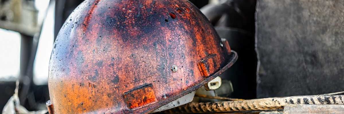 The protective helmet of an oil worker is stained with oil and fuel oil.