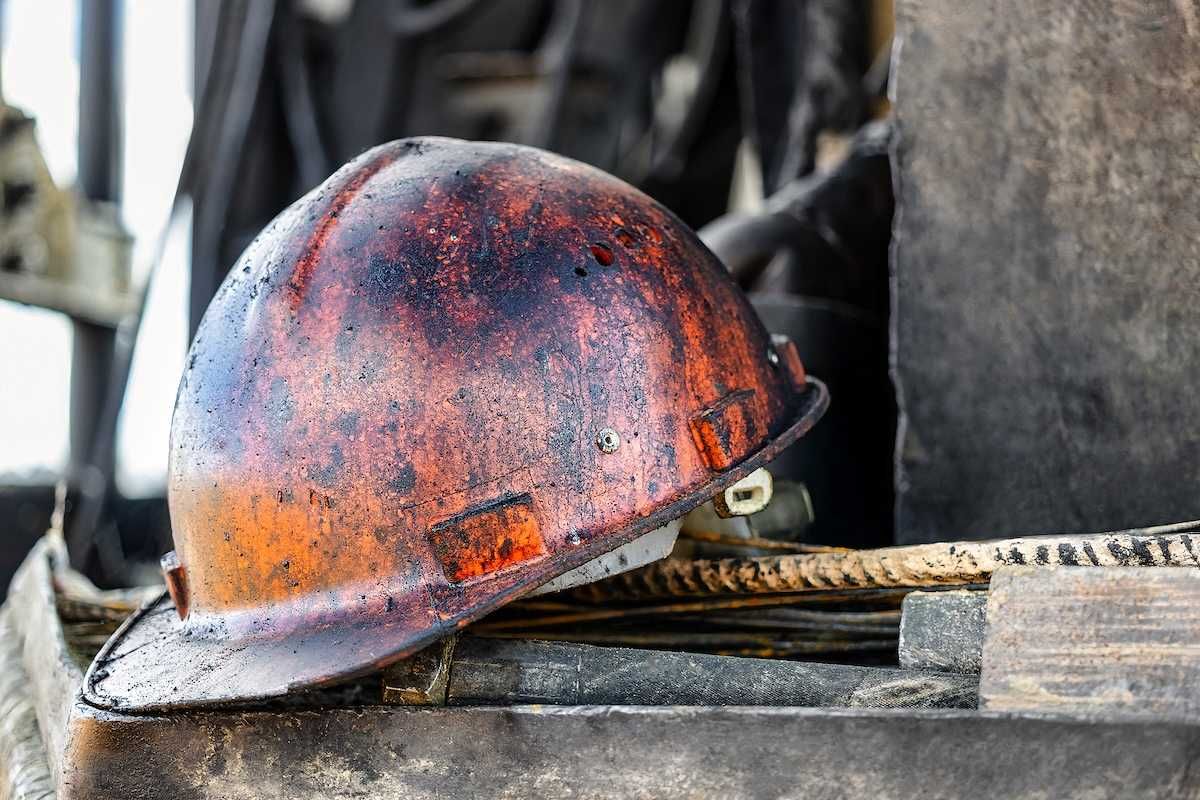 The protective helmet of an oil worker is stained with oil and fuel oil.