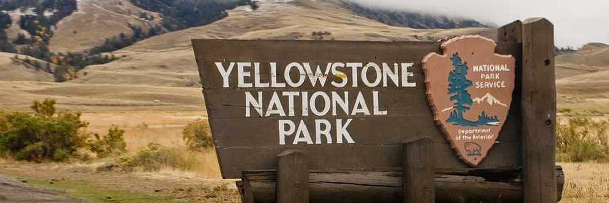 The sign upon entering Yellowstone National Park with hills int he background