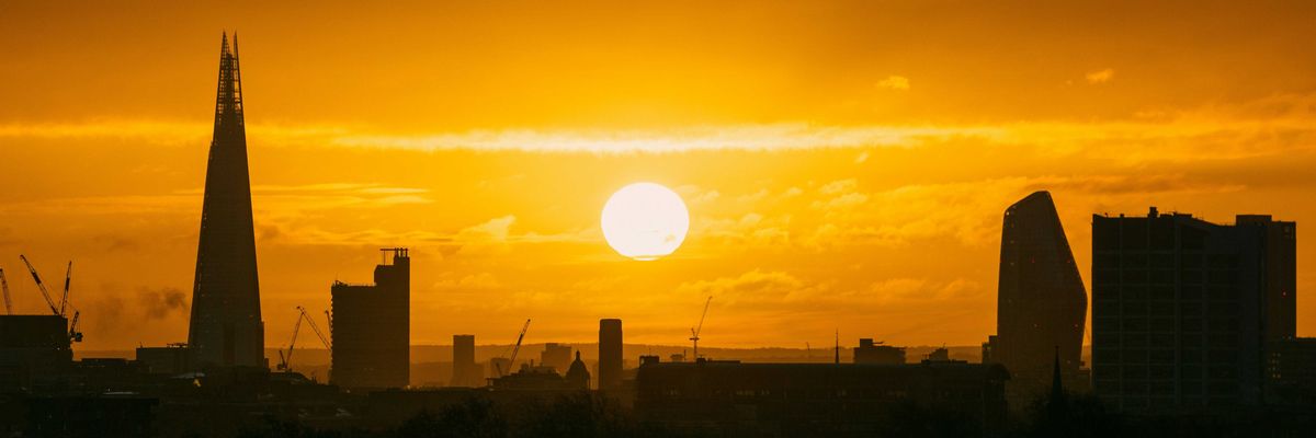 the sun is setting over the city of london.