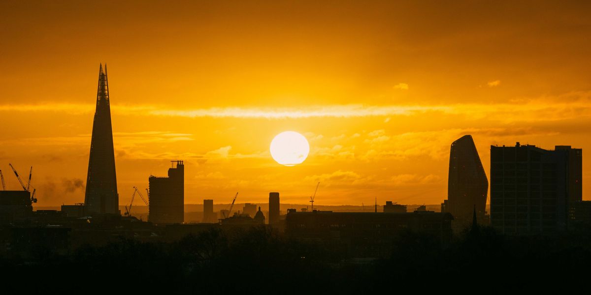 the sun is setting over the city of london.