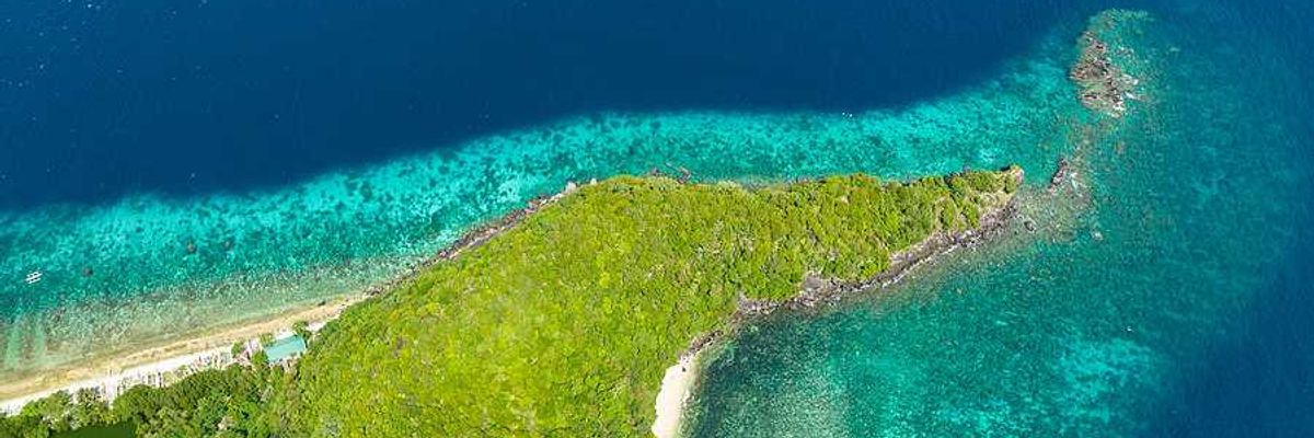The tip of a spit of land with aqua water surrounding it