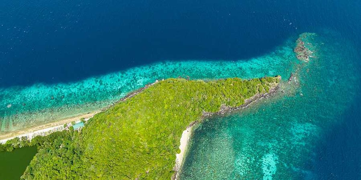 The tip of a spit of land with aqua water surrounding it