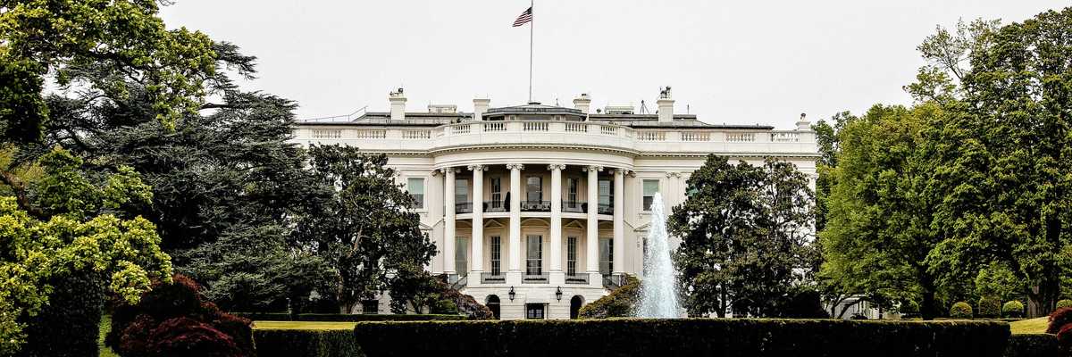 The White House with lawn and trees in foreground.