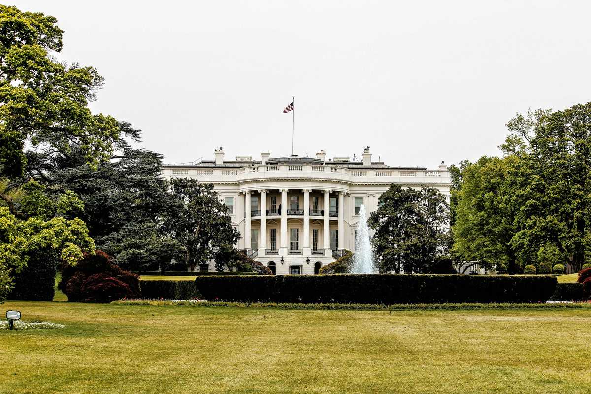 The White House with lawn and trees in foreground.