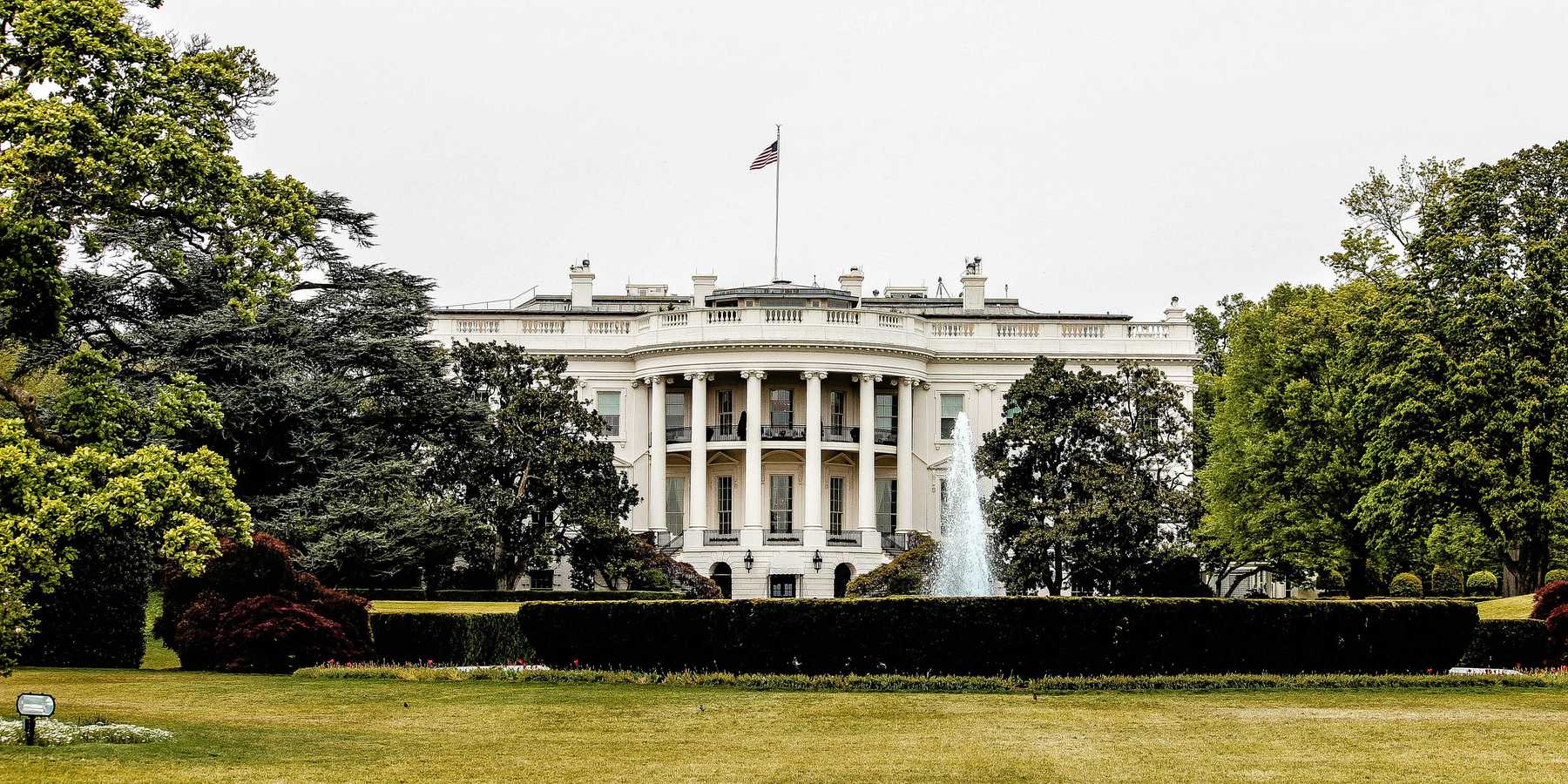 The White House with lawn and trees in foreground.