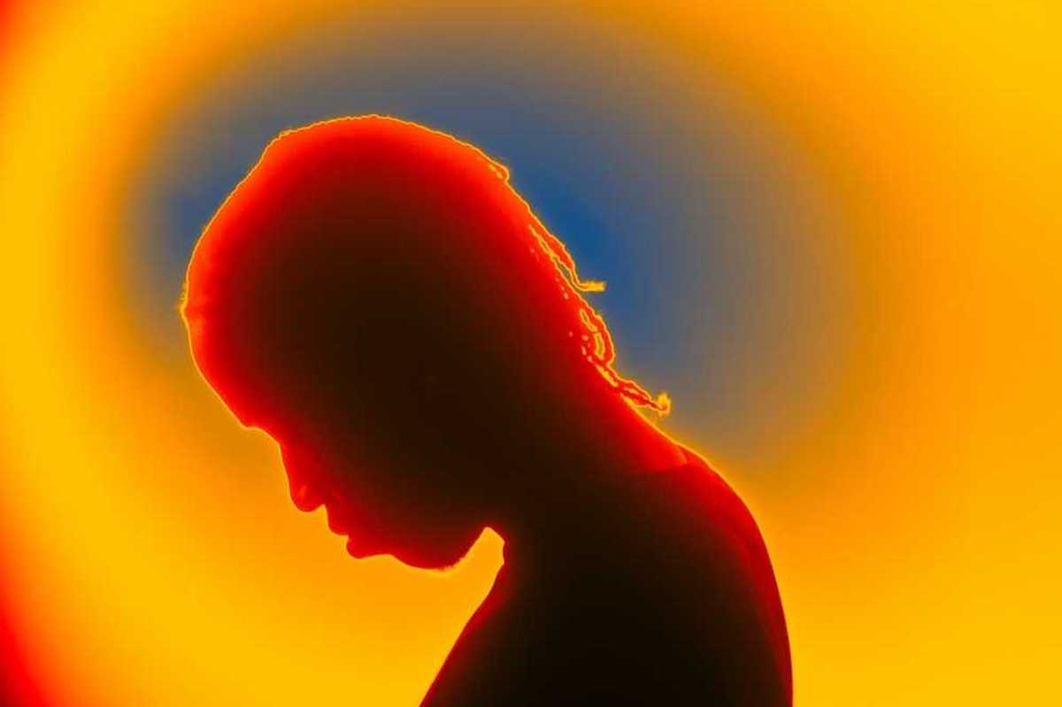 Thermal image of person with bowed head, presumably sad or afflicted with some malady