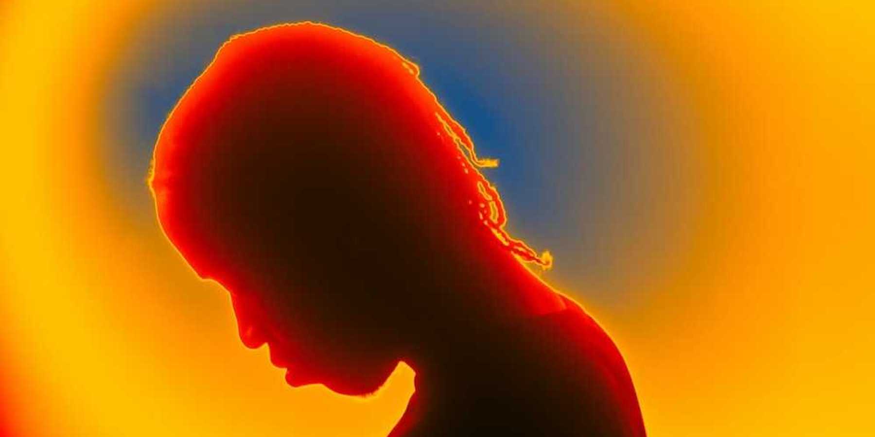 Thermal image of person with bowed head, presumably sad or afflicted with some malady
