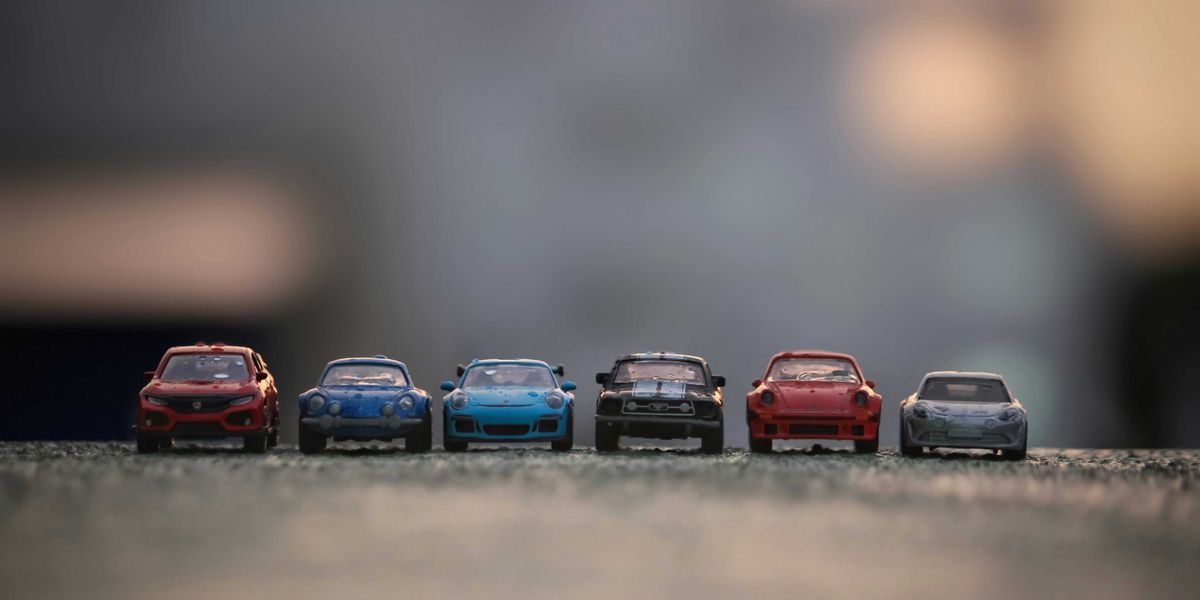 Toy cars lined up on a paved surface