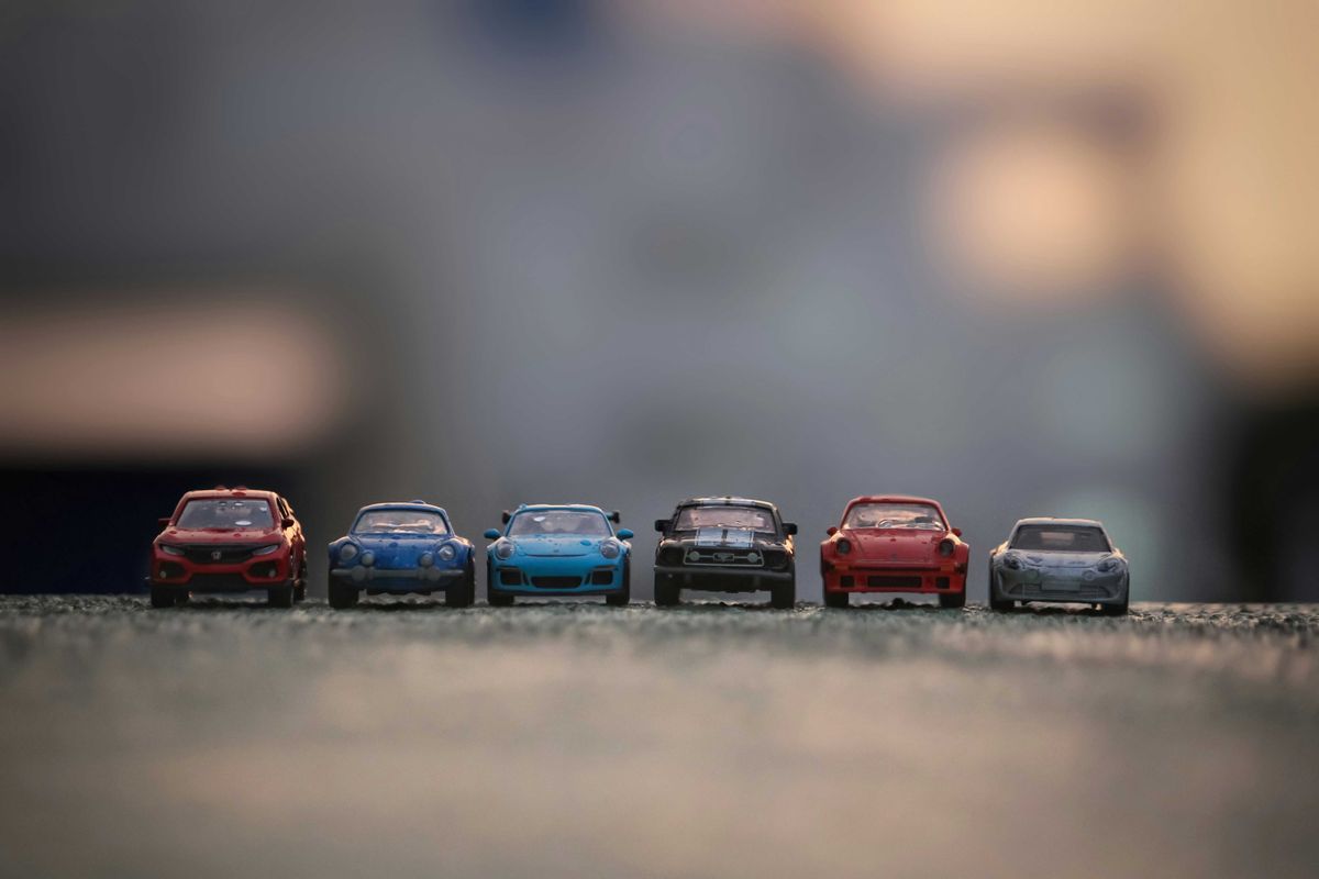 Toy cars lined up on a paved surface