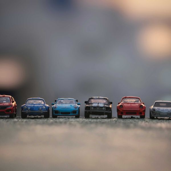 Toy cars lined up on a paved surface