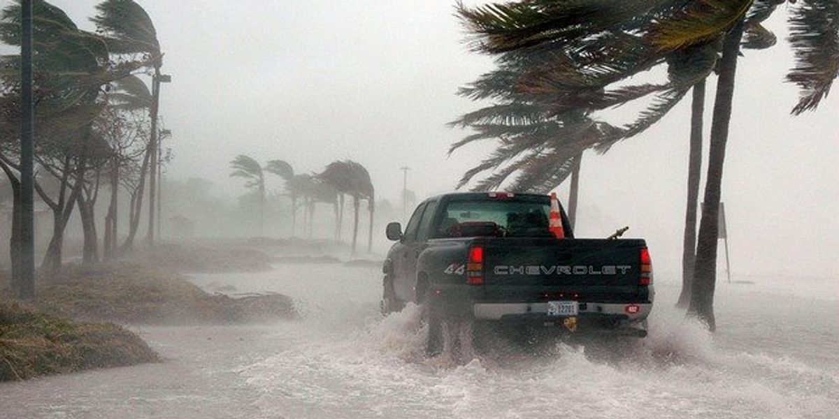 Truck driving through a flooded road during a hurricane.