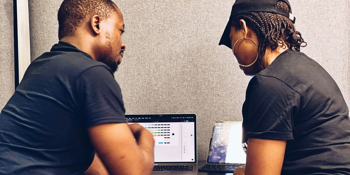 Two Black people looking at a computer