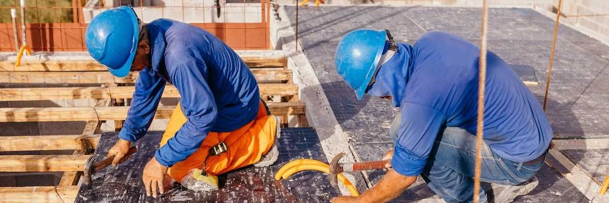 Two construction workers on a hot roof